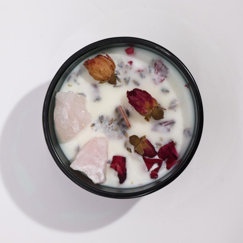 Close-up of rose quartz and dried rose flowers on The Lovers candle